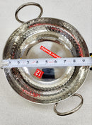 Metallic pot with handles on a light gray background, measured using a ruler.
