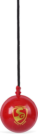 A red synthetic cricket ball with a black hanging cord, branded SG.