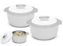 Set of white ceramic cookware with stainless steel lids on a white background