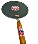 A flat iron tava with a black surface and a wooden handle, featuring a brand logo.